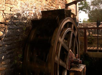 Roue à aube de moulin hydraulique. La chute du ruisseau entraine la roue en rotation. Même à faible vitesse une puissance éléctrique est générée. L'alternateur Allytech fournit une puissance éléctrique qui peu être renvoyée sur le réseau EDF